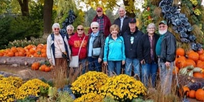 People standing outside with pumpkins in the background